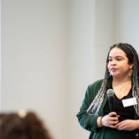 Girls of Color Summit previous event and a women standing giving a speech